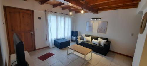 sala de estar con sofá y mesa en Casa Calderon en San Martín de los Andes
