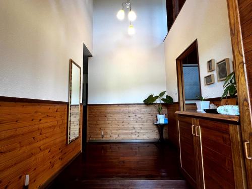 奄美大島の一棟貸切のヴィラAmalog アマログ في Akaoki: ممر مفتوح مع أرضية خشبية وباب