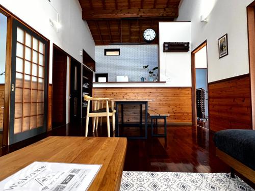 een woonkamer met een tafel en een keuken bij 奄美大島の一棟貸切のヴィラAmalog アマログ in Akaoki