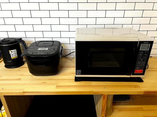 a microwave sitting on top of a wooden table at 奄美の一棟貸切りヴィラ Amalog アマログ in Akaoki