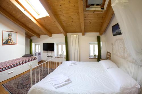 a bedroom with a large white bed and a tv at Piazza Grande City Residence in Trieste
