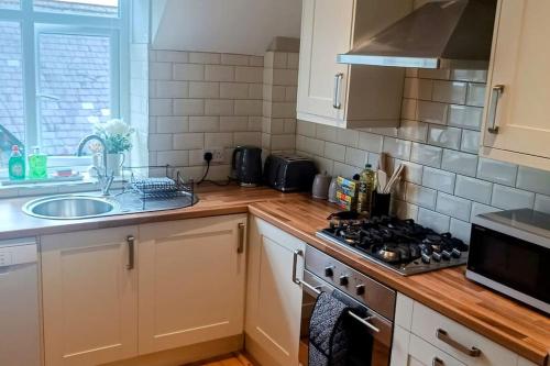 a kitchen with a stove top oven next to a sink at Homebird Property - Rutland Apartment in Harrogate