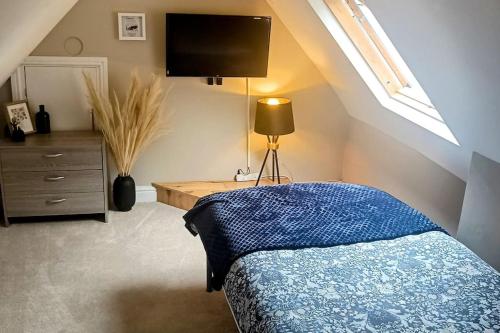 a bedroom with a bed and a tv on the wall at Homebird Property - Rutland Apartment in Harrogate