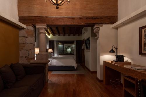 - une chambre avec un lit et un canapé dans l'établissement Maja Hotel Boutique, à Morelia