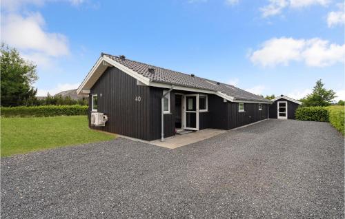 a black house with a gravel driveway at Lovely Home In Haderslev With Sauna in Haderslev