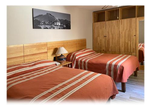 瓦哈卡德華雷斯的住宿－Suites Parador Santo Domingo de G.，酒店客房,设有两张床和一盏灯