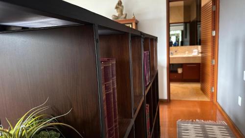 a large wooden book shelf in a living room at Maja Hotel Boutique in Morelia