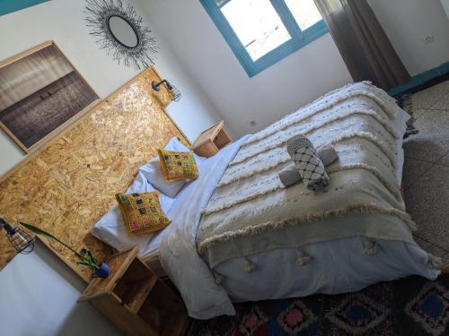 a bedroom with a large bed with pillows on it at Taghazout Roof Hostel in Taghazout