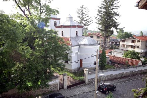 a small white church with a car parked in front of it at Family Hotel Bansko Sofia in Sofia