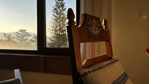 a wooden chair sitting in front of a window at Maja Hotel Boutique in Morelia