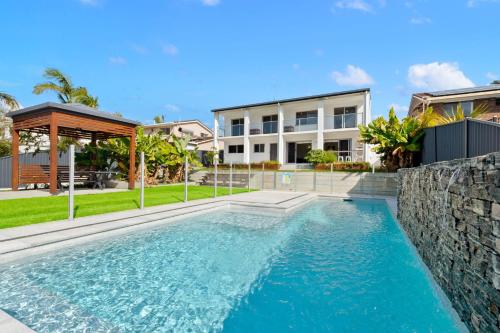 a swimming pool in front of a house at 4 bedroom fabulous home on canal in Mooloolaba
