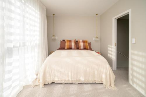 a bedroom with a bed with a large window at Downtown Mount Maunganui in Mount Maunganui