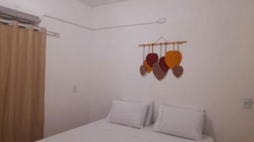 a bedroom with a bed with two pillows and a curtain at Quarto Dani in Jericoacoara