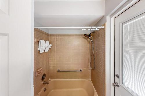 a bathroom with a tub and a shower at Dolphin Court #3 in St. Pete Beach