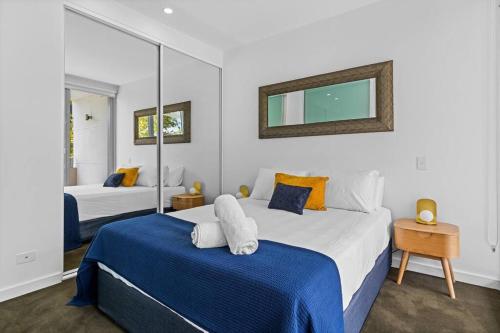a bedroom with two beds and a mirror at Apartment on Honeysuckle in Newcastle