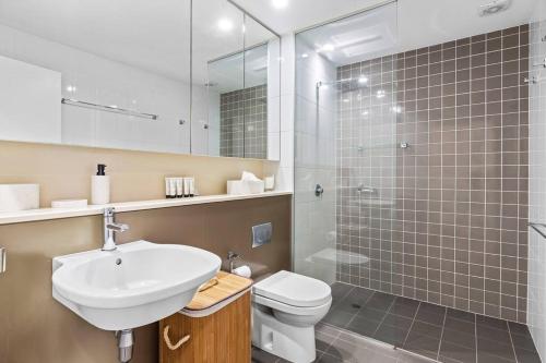 a bathroom with a sink and a toilet and a shower at Apartment on Honeysuckle in Newcastle