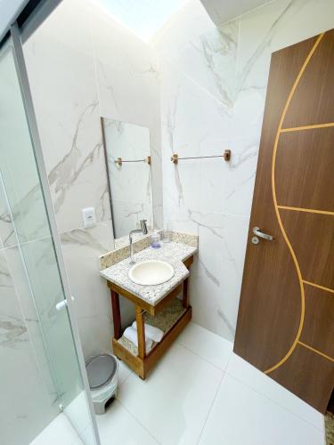 a bathroom with a sink and a mirror at Suítes Naldiane in Imbassai