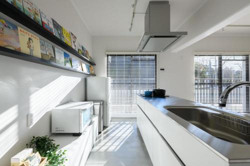 a kitchen with white counters and a sink at Ehon Hotel in Nara