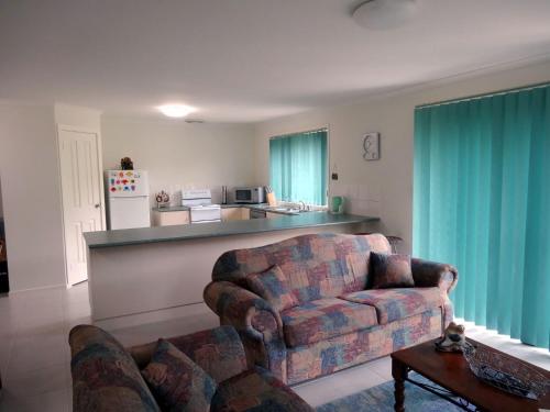 een woonkamer met een bank en een keuken bij Relaxing Holiday Home Pets Are Welcome in Victor Harbor