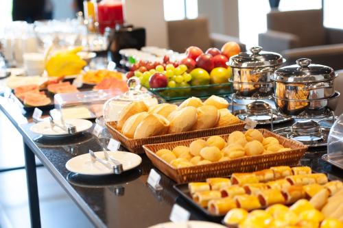 un buffet avec de nombreux types de nourriture sur une table dans l'établissement Grande Avenida Hotel, à Patrocínio