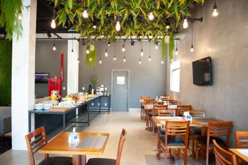 a restaurant with wooden tables and chairs and lights at Grande Avenida Hotel in Patrocínio