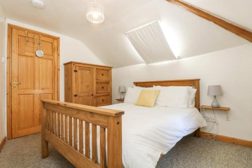 1 dormitorio con cama de madera y puerta de madera en The Wagon Linney en Bude