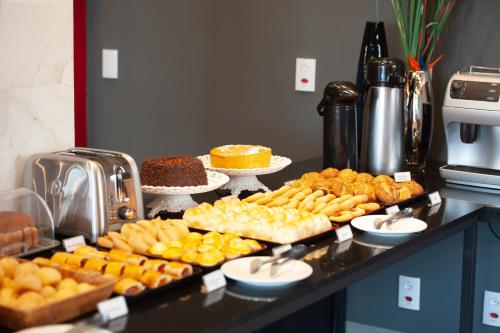 a buffet with many different types of food on a counter at Grande Avenida Hotel in Patrocínio
