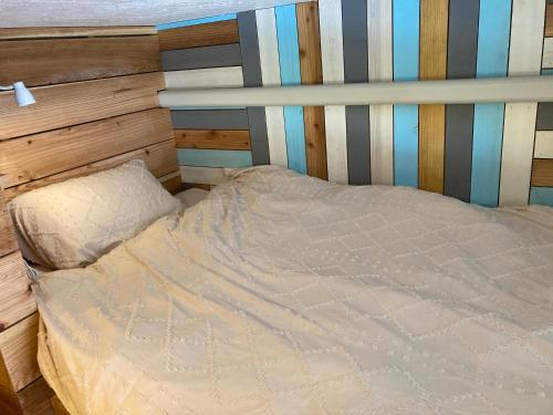 a bed in a bedroom with a wooden headboard at Surfer's Cafe& Hostel in Chatan