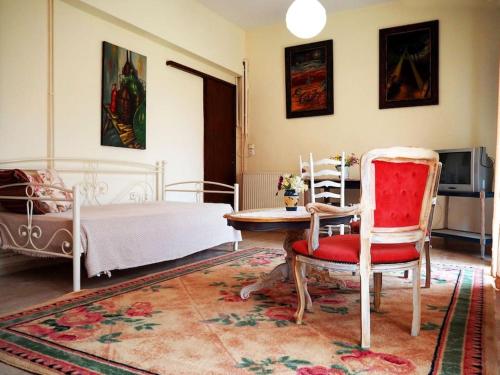 1 dormitorio con 1 cama, 1 silla y 1 mesa en painter's house, en Ágios Ioánnis