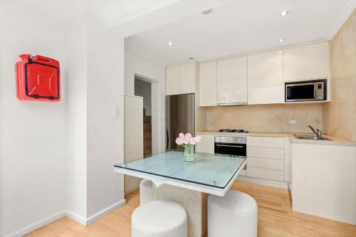 uma cozinha com uma mesa com um vaso de flores em Paddington house beautiful 2 bedroom terrace em Sydney