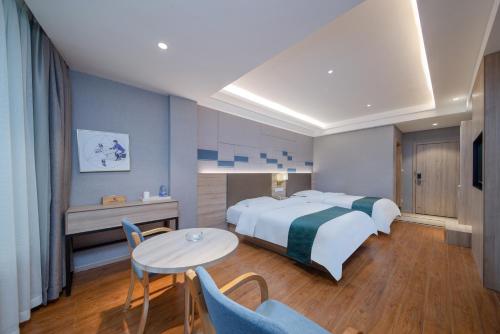 a hotel room with a bed and a table and chairs at Morninginn, Zhenyu Plaza in Shaoyang County