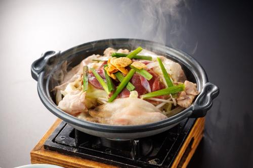 a pot of food on top of a stove at Hotel Kamogawaso in Takekara