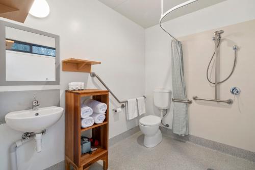 a bathroom with a sink and a toilet and a shower at Swansea Beach Chalets in Swansea