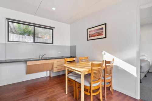 a kitchen and dining room with a table and chairs at Swansea Beach Chalets in Swansea