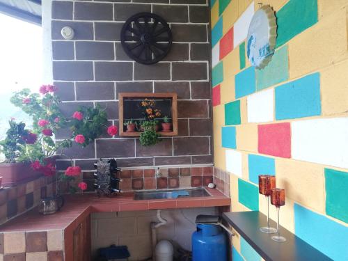 una cocina con una pared de ladrillo colorido con fregadero en Green Bamboo Lodge, en San Francisco de Borja