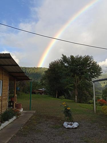 a rainbow in the sky over a yard at Green Bamboo Lodge in San Francisco de Borja