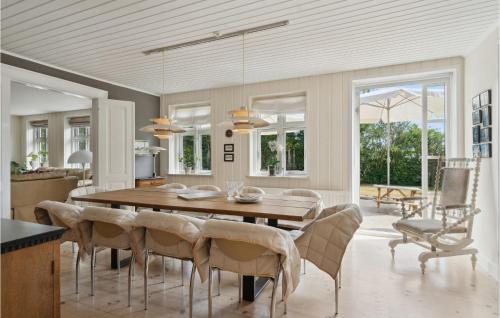 a dining room with a wooden table and chairs at 4 Bedroom Nice Home In Nyborg in Nyborg