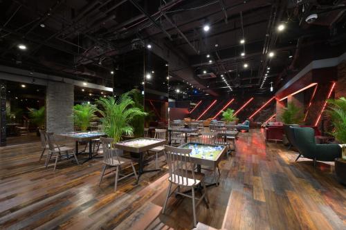 um restaurante com mesas e cadeiras e vasos de plantas em Hotel Bali Tower Osaka Tennoji em Osaka