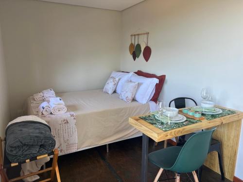 a small bedroom with a bed and a table at Alto da Villa in Ouro Preto