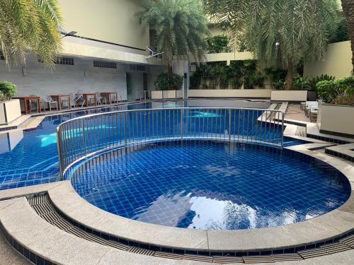 a large blue swimming pool in a building at Jomtien Holiday Pattaya in Jomtien Beach