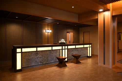 a lobby with a reception desk and two stools at Kasuitei Ooya in Fujikawaguchiko