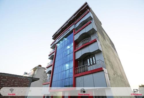 um edifício alto com uma fachada vermelha e azul em SPOT ON Hotel Doon Sabri em Roorkee