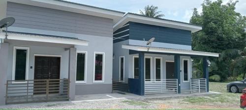 una casa con una fachada azul y blanca en D'NAS HOMESTAY - Muslm Only, en Sungai Besar