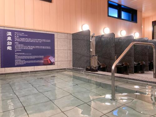 a swimming pool with a shower in a building at HOTEL LiVEMAX PREMIUM Sapporo Odorikoen in Sapporo