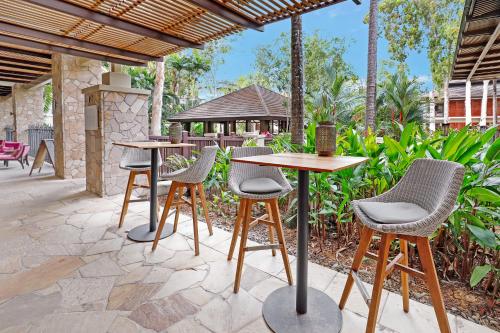 a group of tables and chairs on a patio at Temple 2 Bedroom Penthouse in Palm Cove