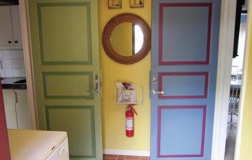 cocina con puertas verdes y espejo en 2 Bedroom Beautiful Home In Skillinge, en Skillinge