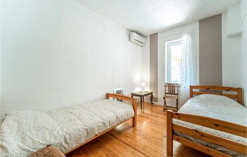 1 dormitorio con 2 camas y ventana en Beautiful Home In Villegly With Kitchen, en Villegly