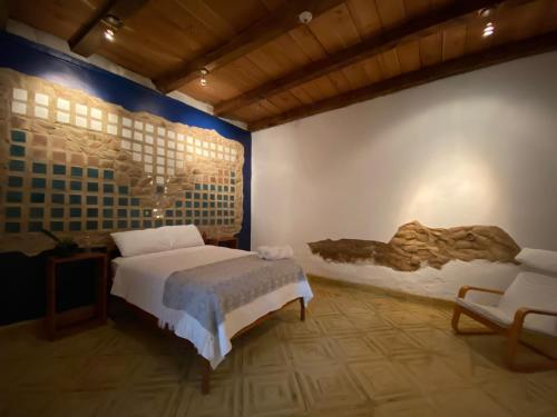ein Schlafzimmer mit einem Bett und einem Stuhl darin in der Unterkunft Casa Cristal in Chiapa de Corzo