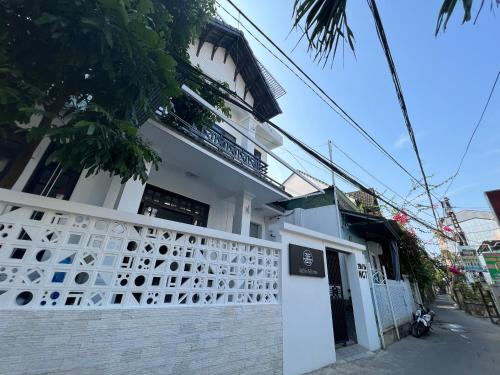 ein weißes Gebäude mit einem Zaun davor in der Unterkunft ANH’s HOUSE in Hue