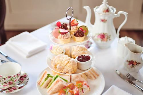 a three tiered tray of desserts and pastries on a table at Prince's Gate Hotel in Rotorua